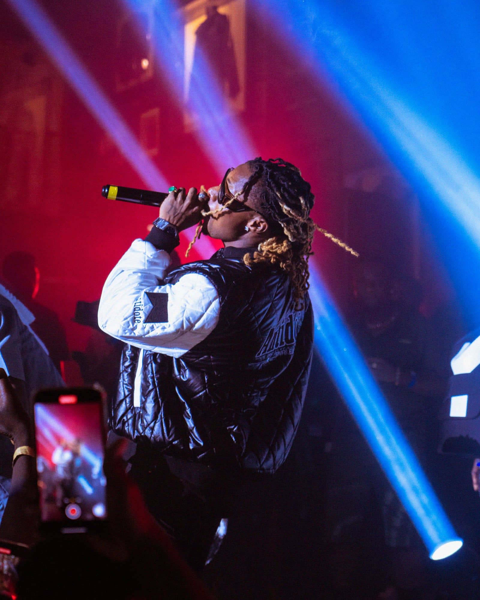 A rapper performing under red and blue stage lights