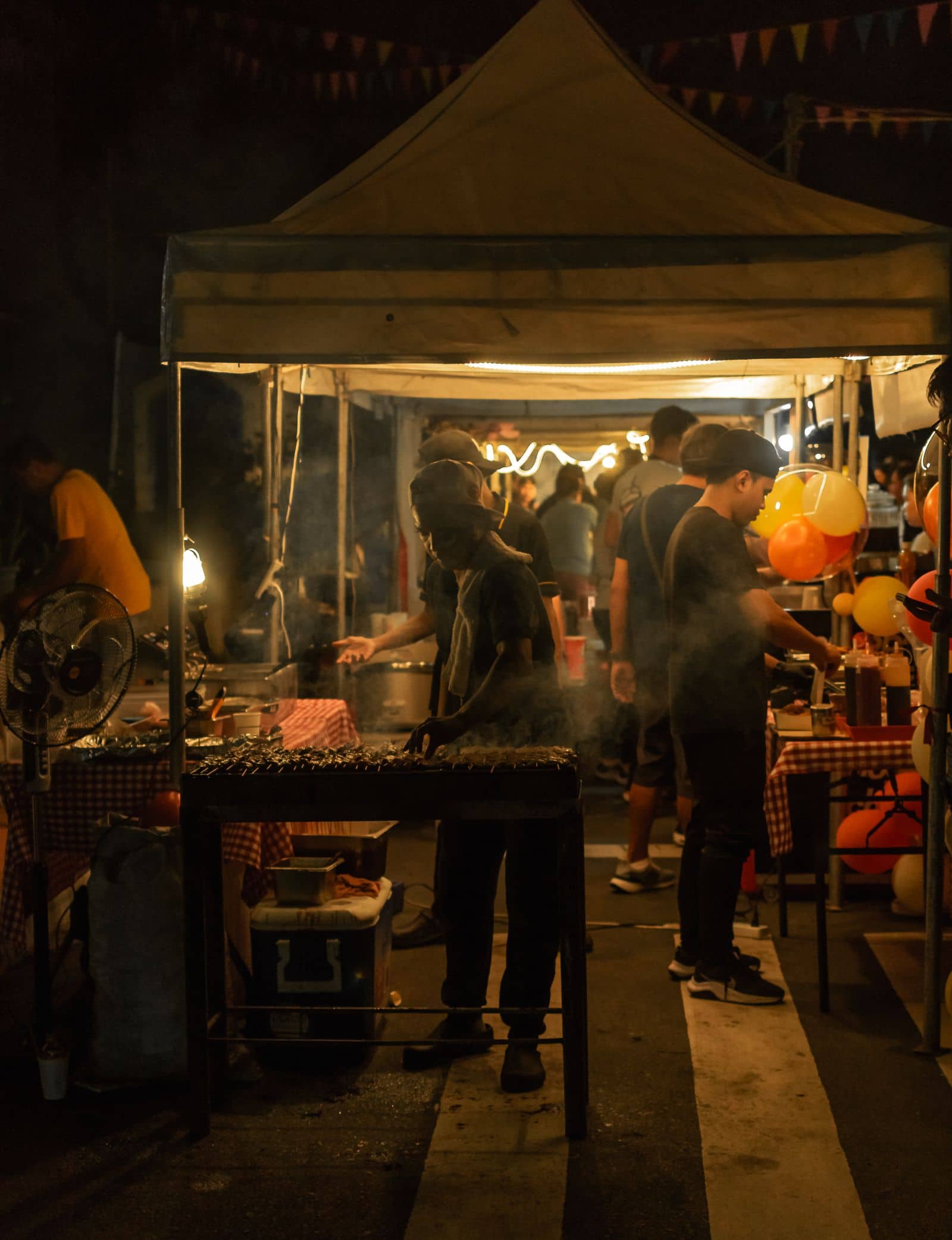 A busy night market lined with lit food stalls